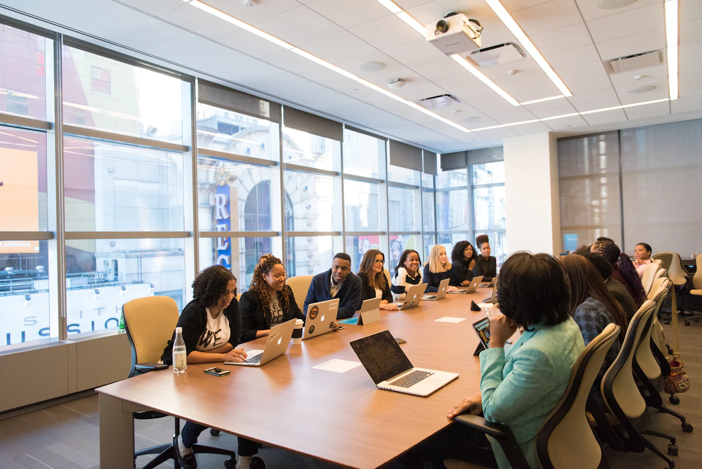 Long modern conference room with floor-to-ceiling windows and a team seated at the table
