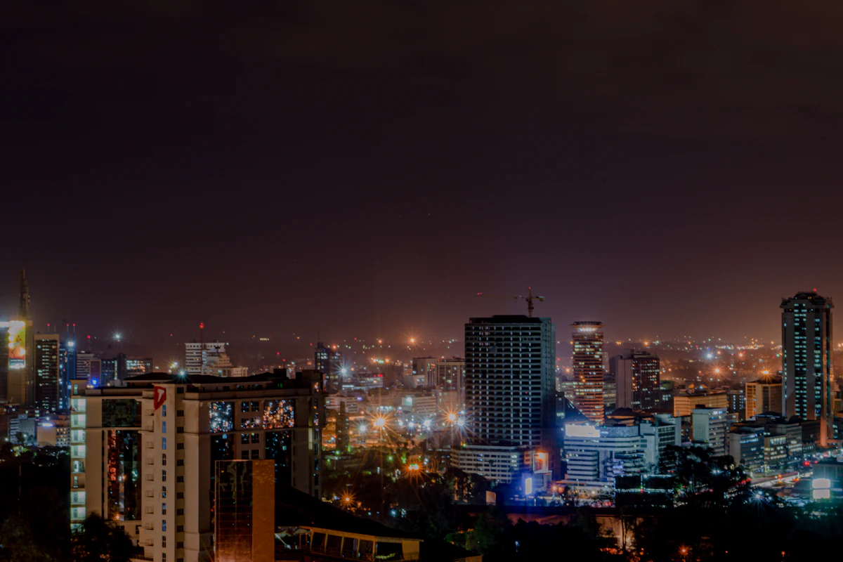 Nairobi city lights and office towers glowing at night under a dark sky